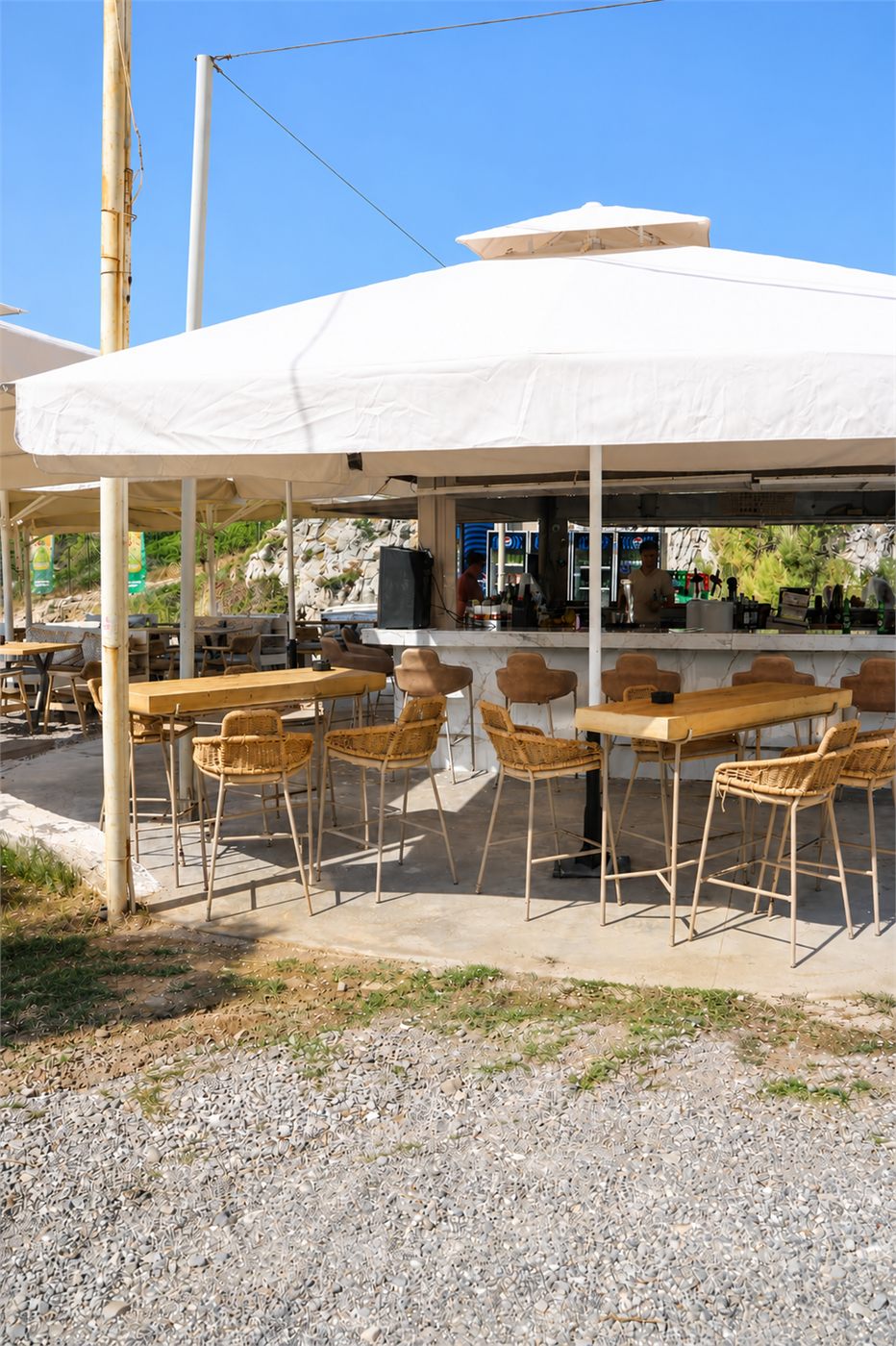 White umbrellas and sunbeds on the beach at Boufos